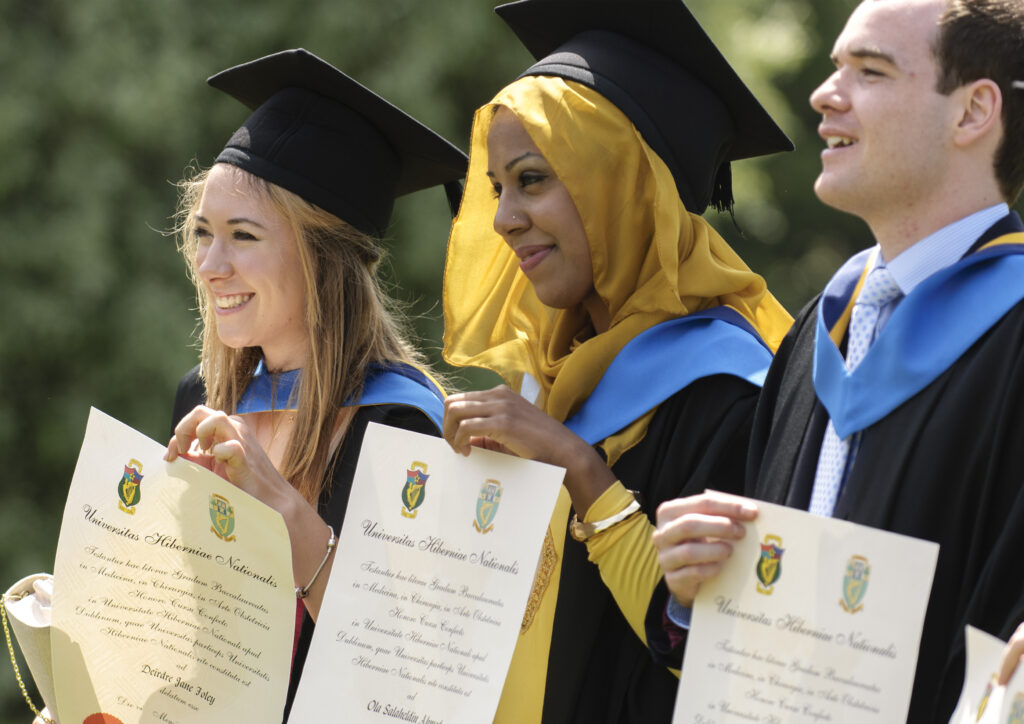Irish university graduates holding their diplomas